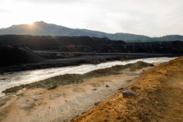 Landscape of abandoned territory with dirty water in river and polluted soil